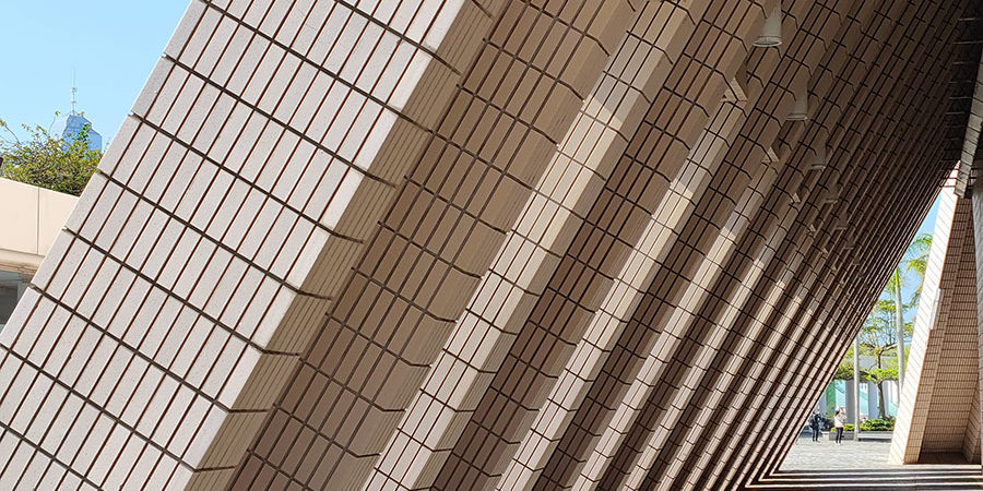 01_geom_triangular_buttress Cream-colored buttresses lean against a building as a form of architectural support. Similar to the way online rental platforms support construction rental companies to keep an efficient and successful workflow.