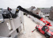 Manitou-Teleskoplader mit Mannschaufel auf einer Baustelle