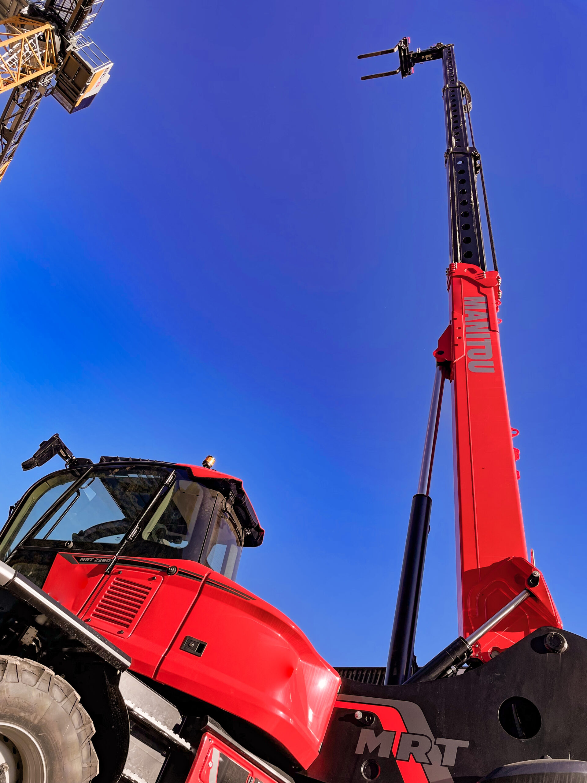 Manitou MRT telehandler reaching up to the height of cranes