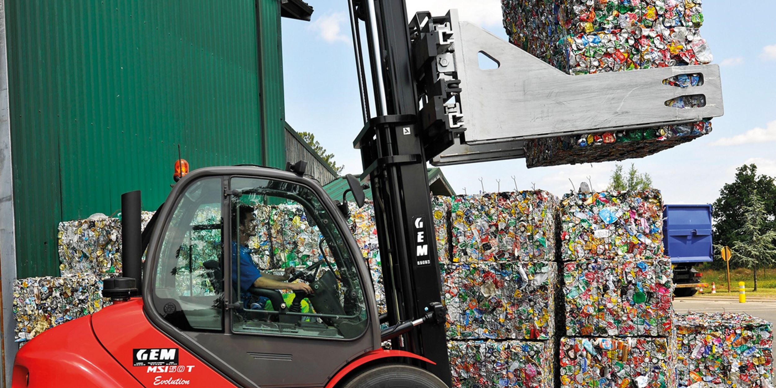 niederstaetter-halbindustrieller-gabelstapler-manitou-msi-50_00 An extendable forklift mast being used to stack blocks of compressed bottles and cans